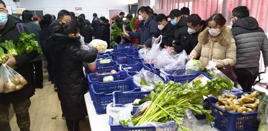 居民在平价蔬菜供应点挑选商品